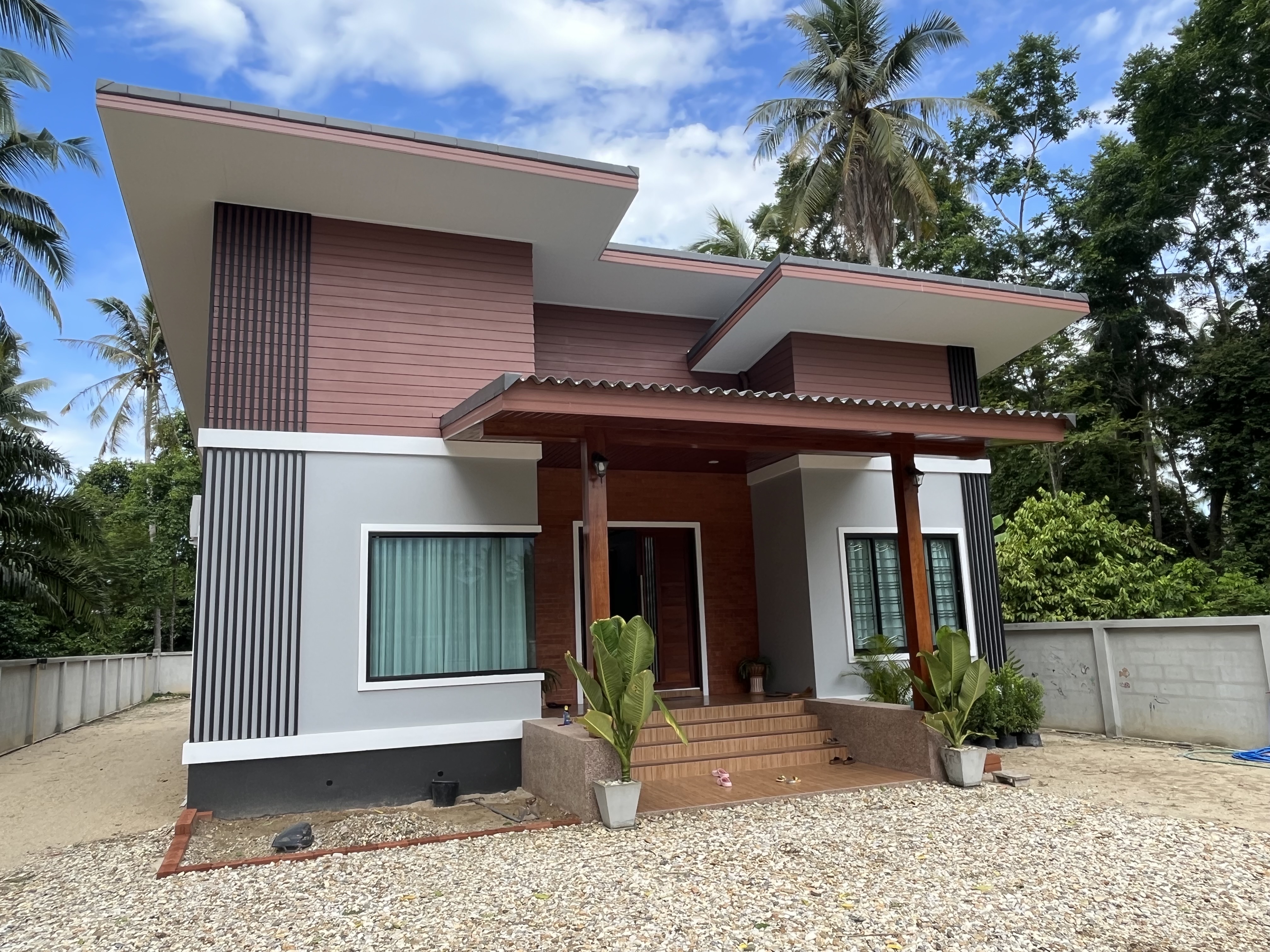 Single-storey house in Thasala with sloping roofs, a sheltered porch and warm-toned exterior accents